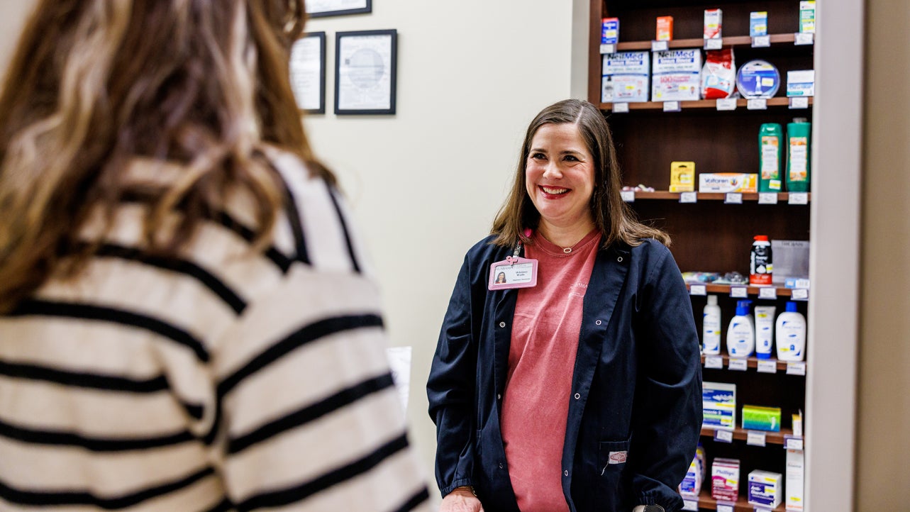 a pharmacist helps a student fill a prescription at the student health center and pharmacy