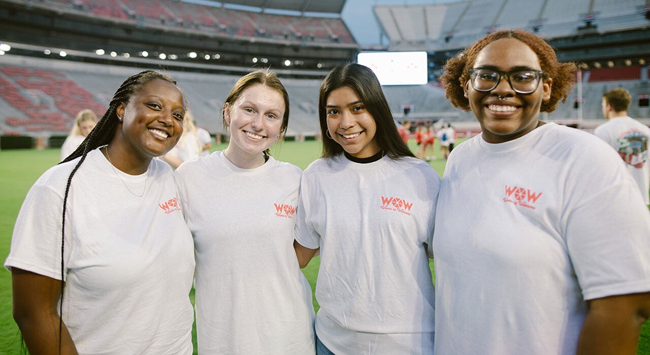 Four female students pose in Bryant Denny Stadium.