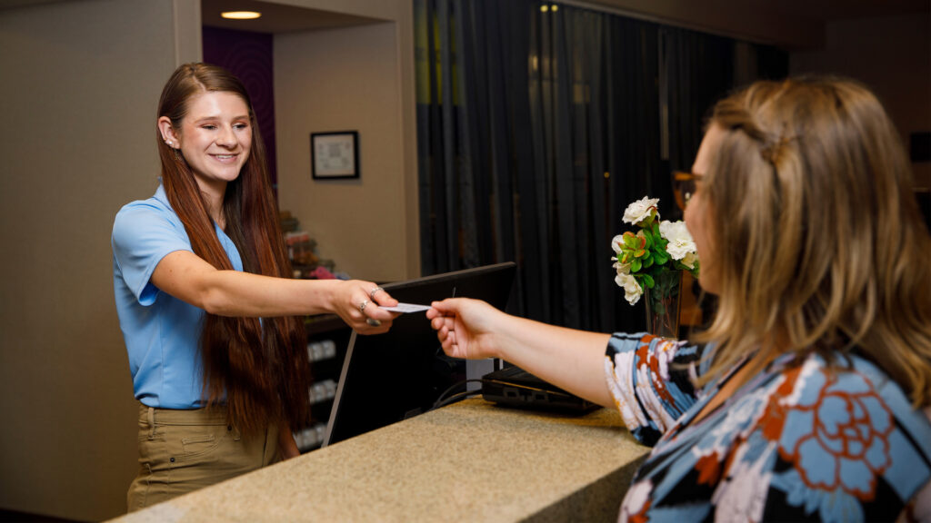 Hotel staff member handing a credit card to a guest during check in