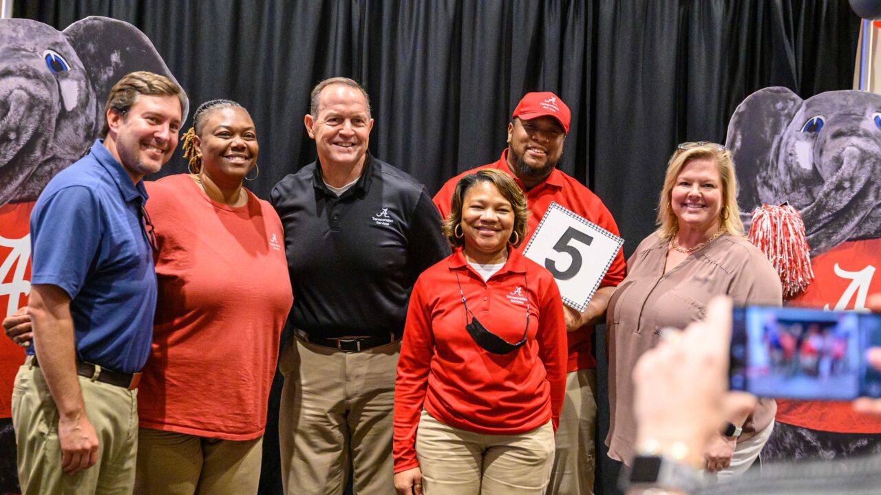 group of employees pose with Big al