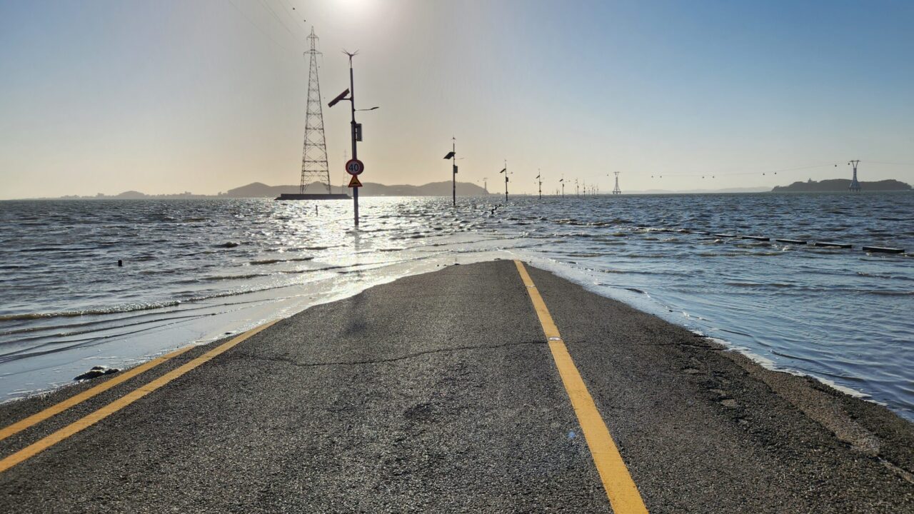 The view of a road submerged in the sea at high tide