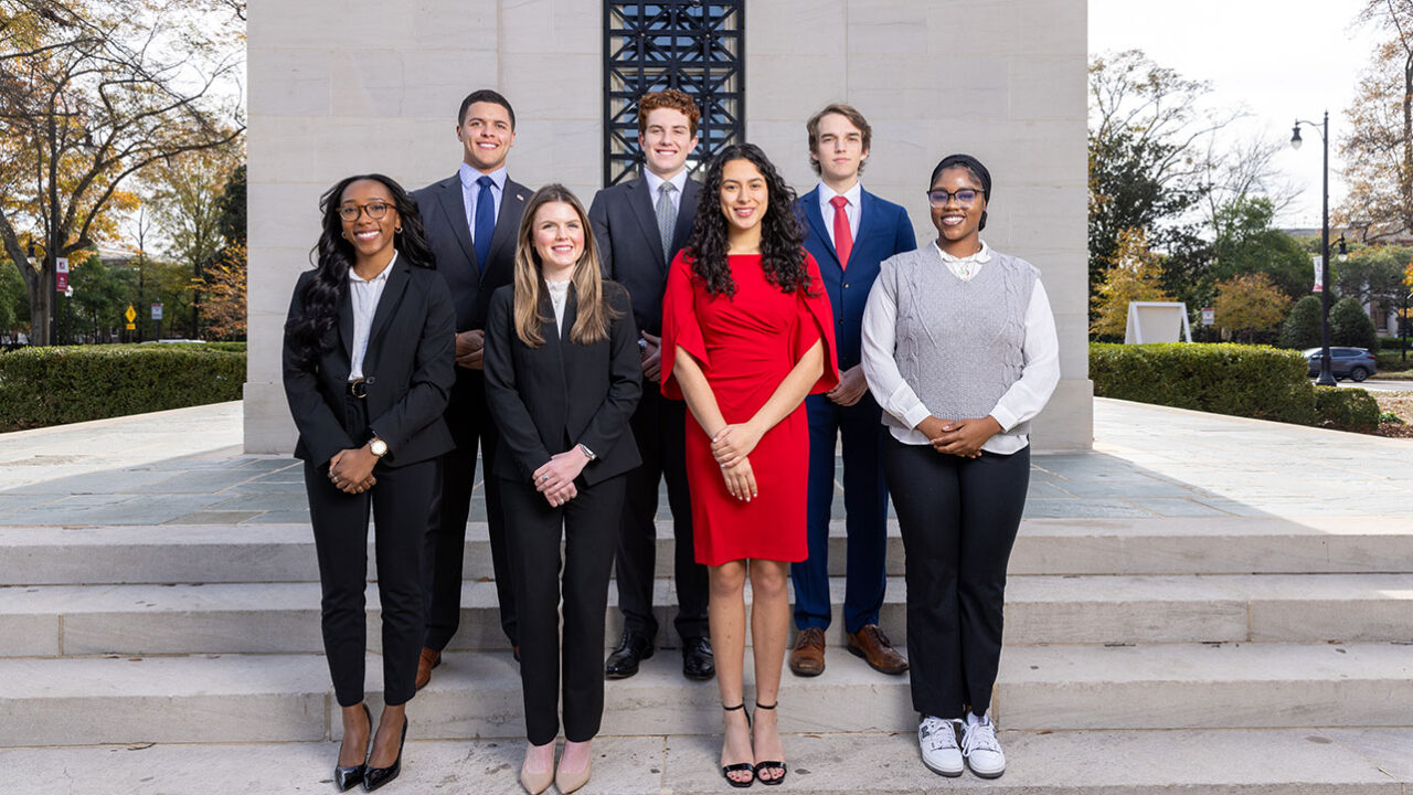 A group of college students pose in front of Denny Chimes.