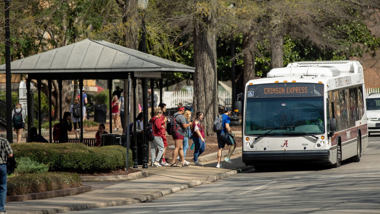 passengers getting on a Crimson ride bus at a stop