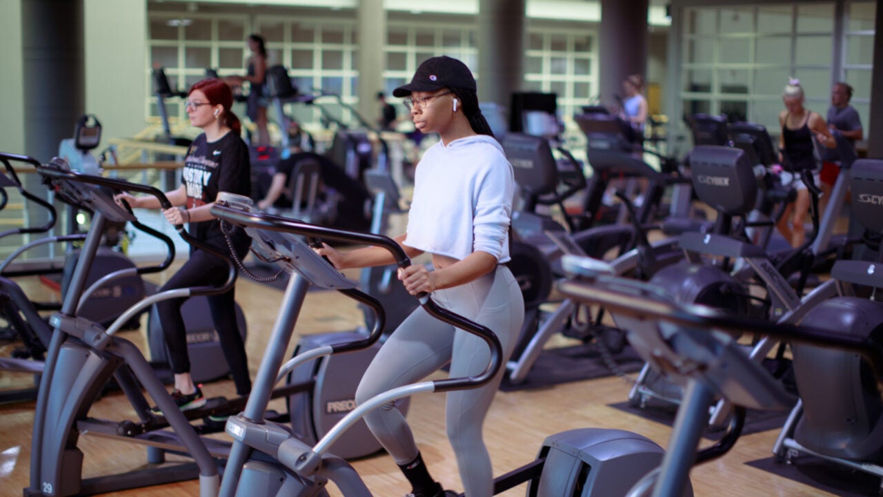 a young woman works out on an elliptical machine at the University of alabama student recreation center