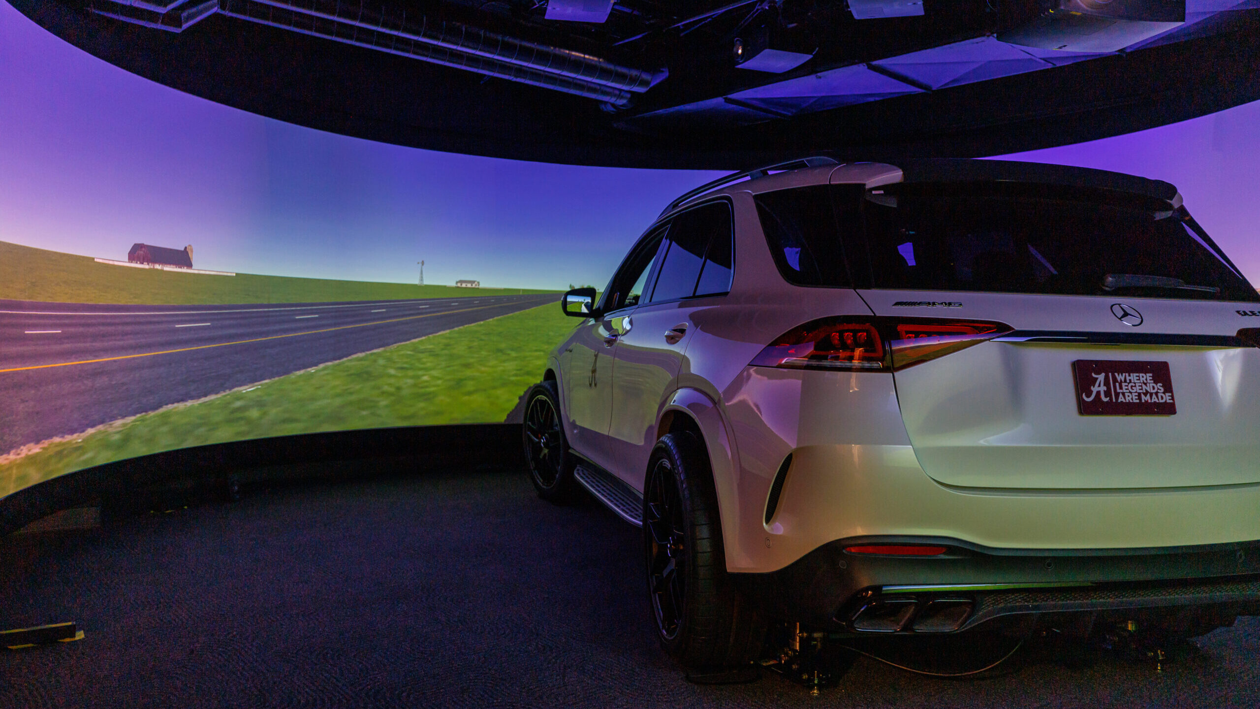 Mercedes 350GLE body fitted with driving simulator software sits in front of a curved screen.