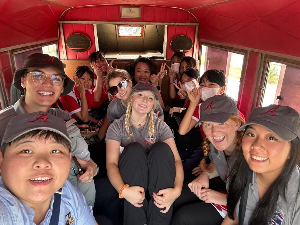 Several scholars riding on a bus