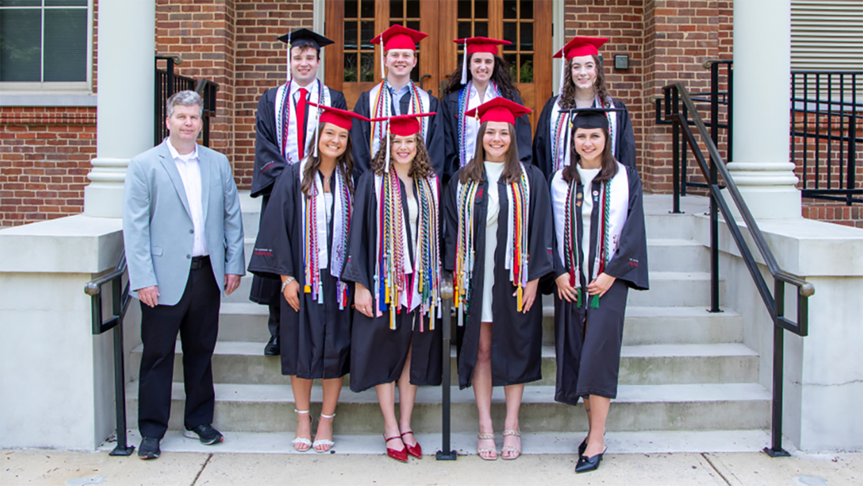 A group of students wearing caps and gowns for graduation.