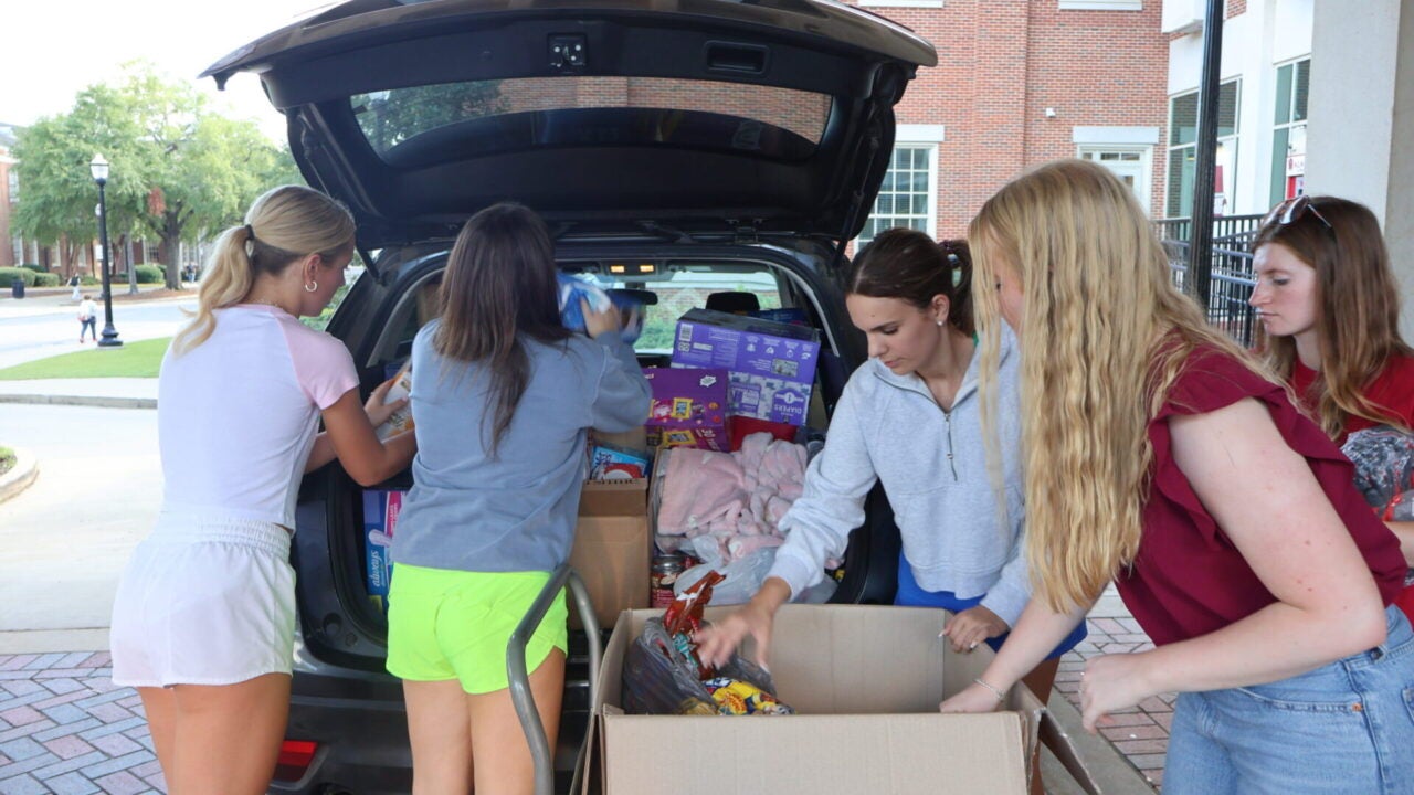 Students load the back of an S U V with donations