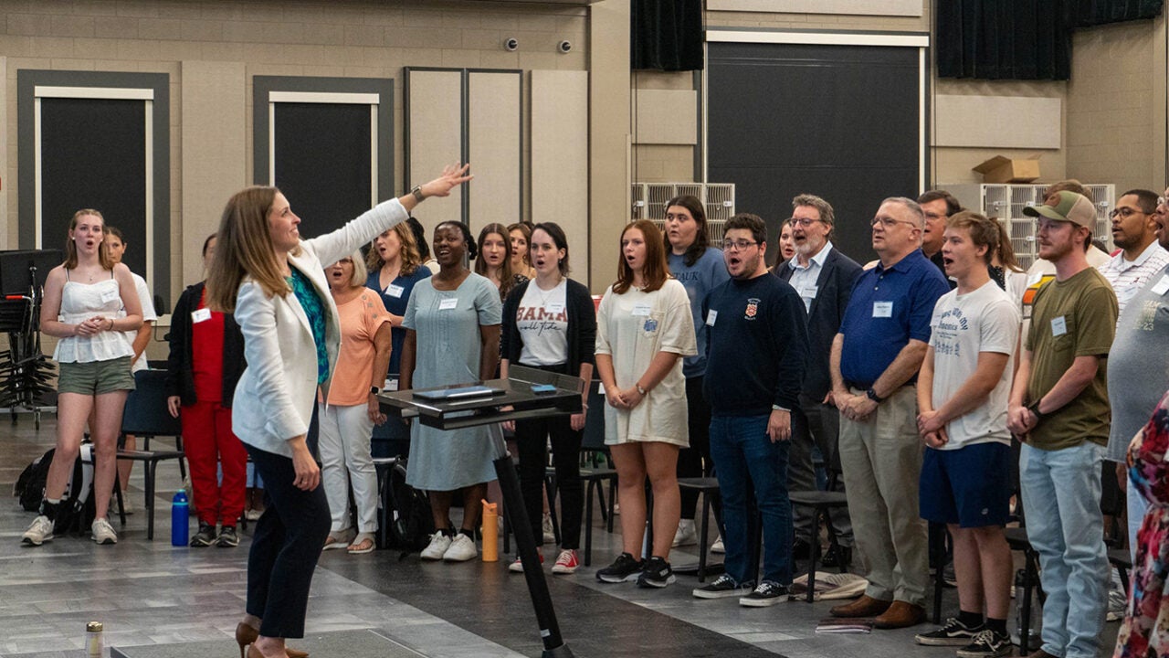 Dr. Morgan Luttig leads a group of singers.