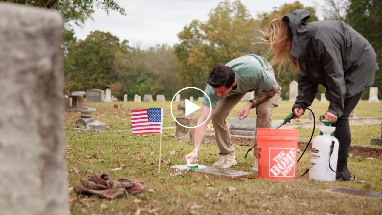 Two members of the Campus Veterans Association clean a grave