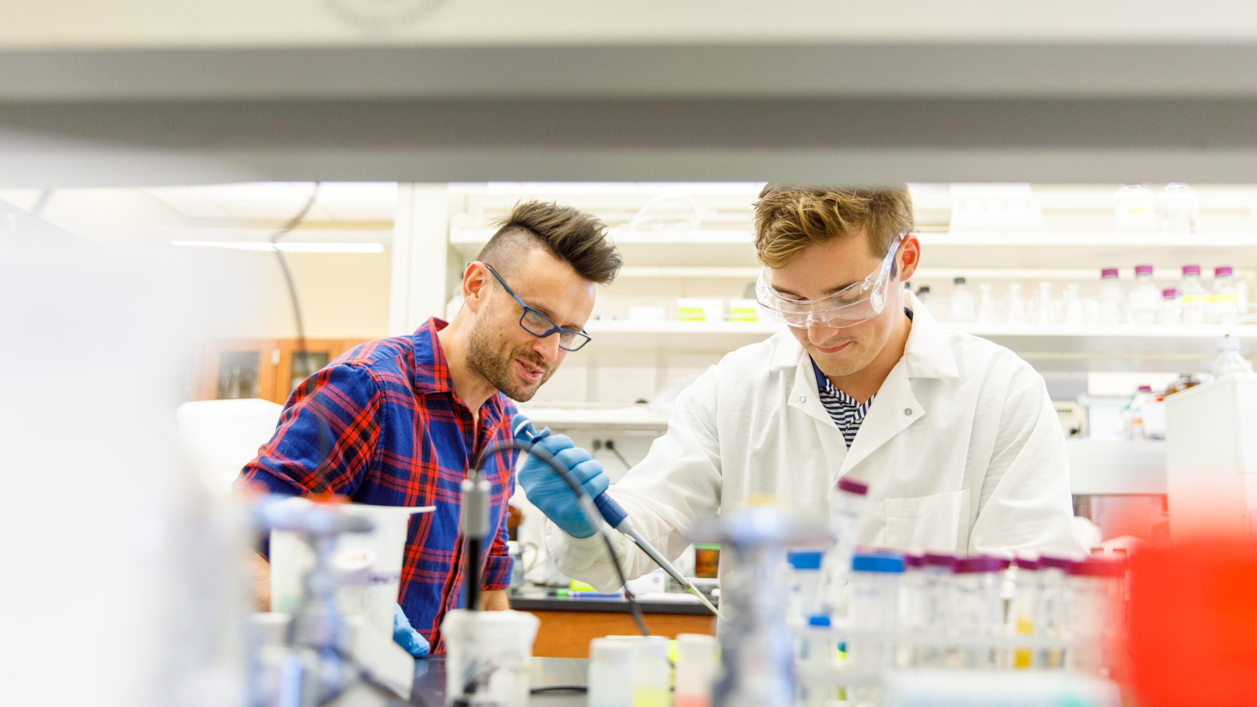 Dr. Lukasz Ciesla and a student work in a lab setting