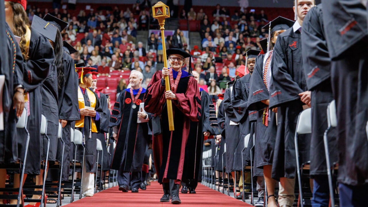 the faculty marshal leads the procession