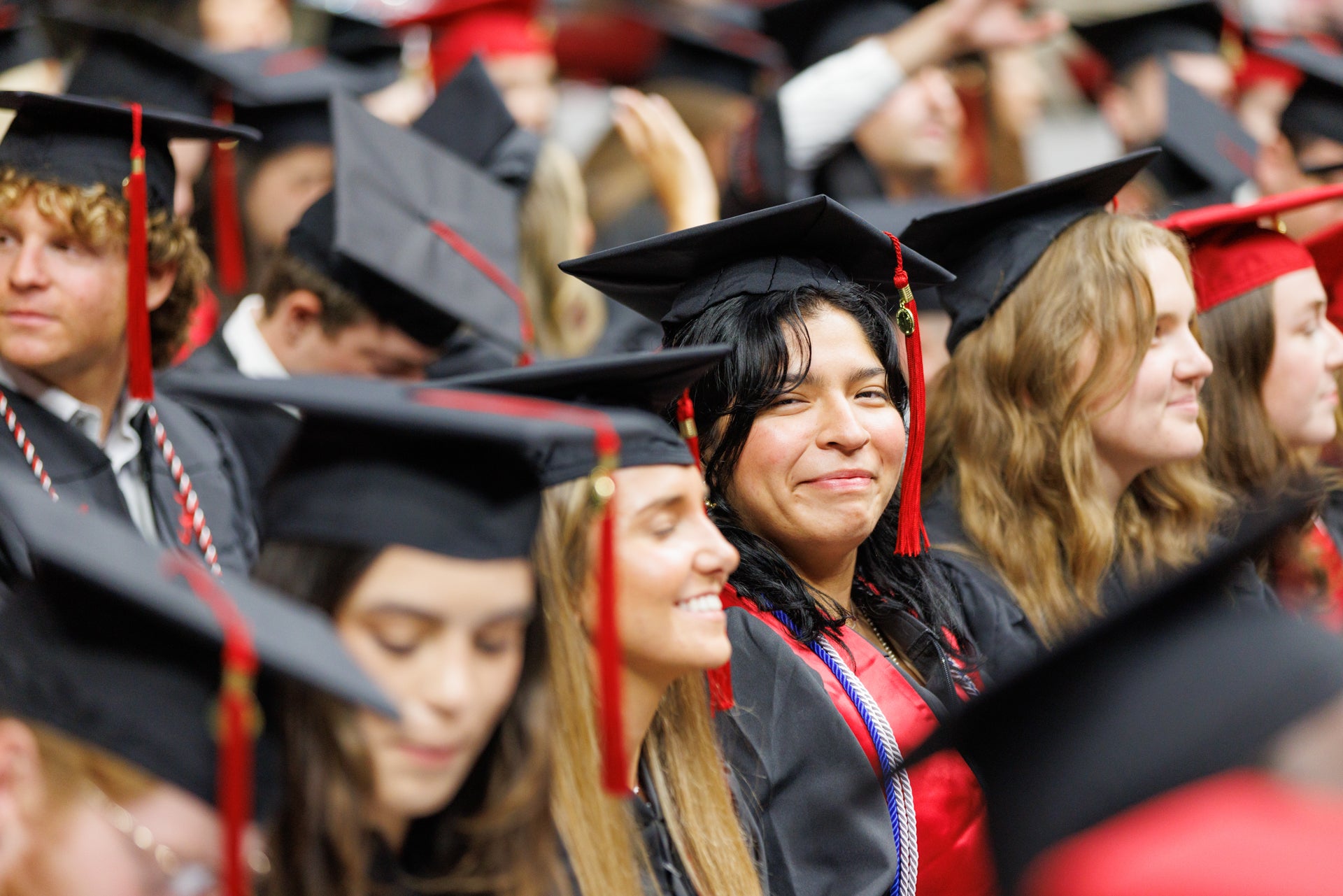 a young women smiles at the camera during a commencement ceremony