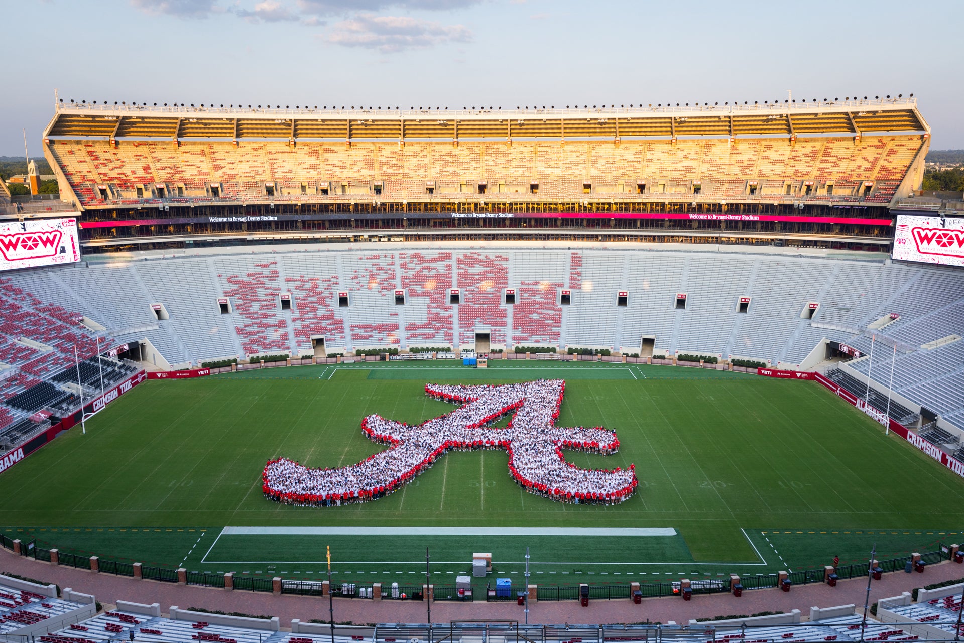 students on the football filed in the shape of the script A