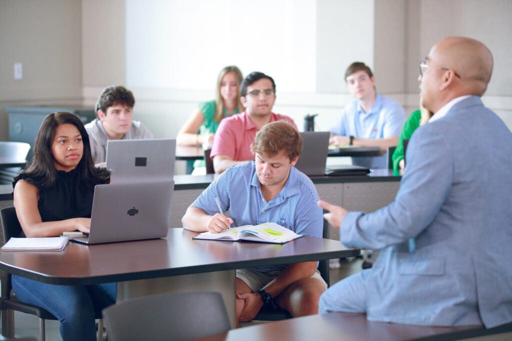 students listen to a teacher in a classroom