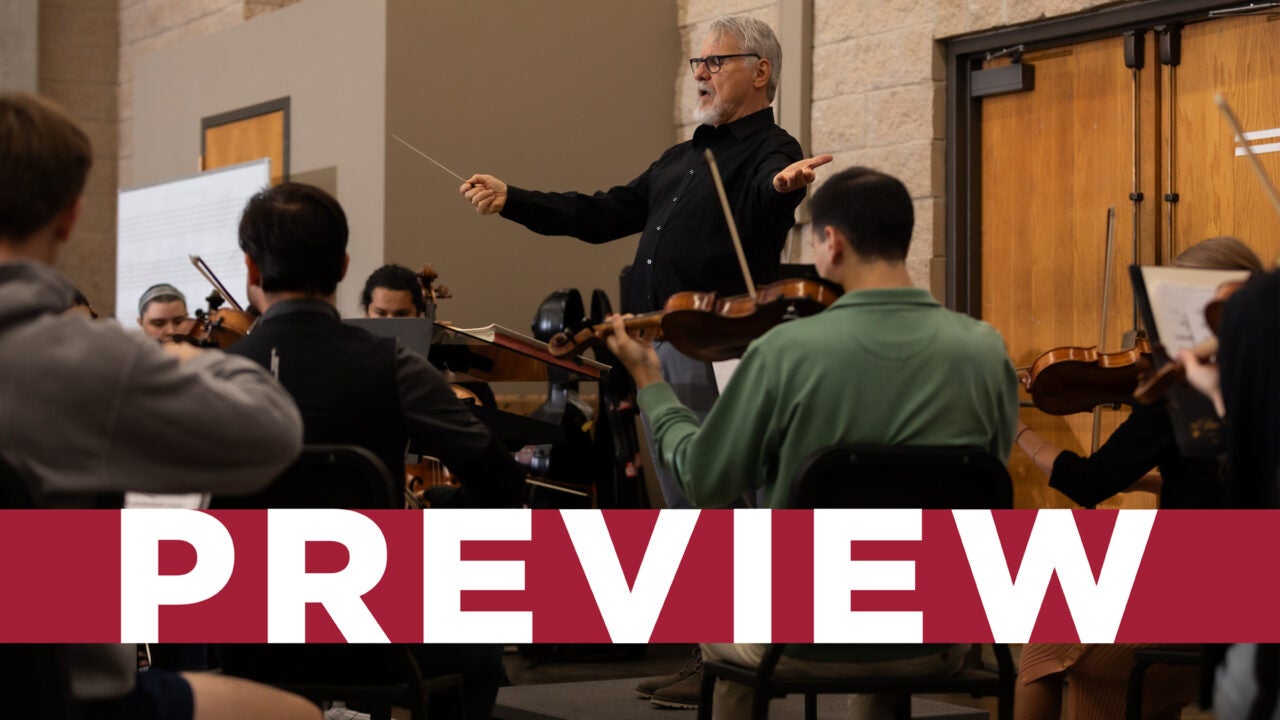 A music conductor leading a group of violinists