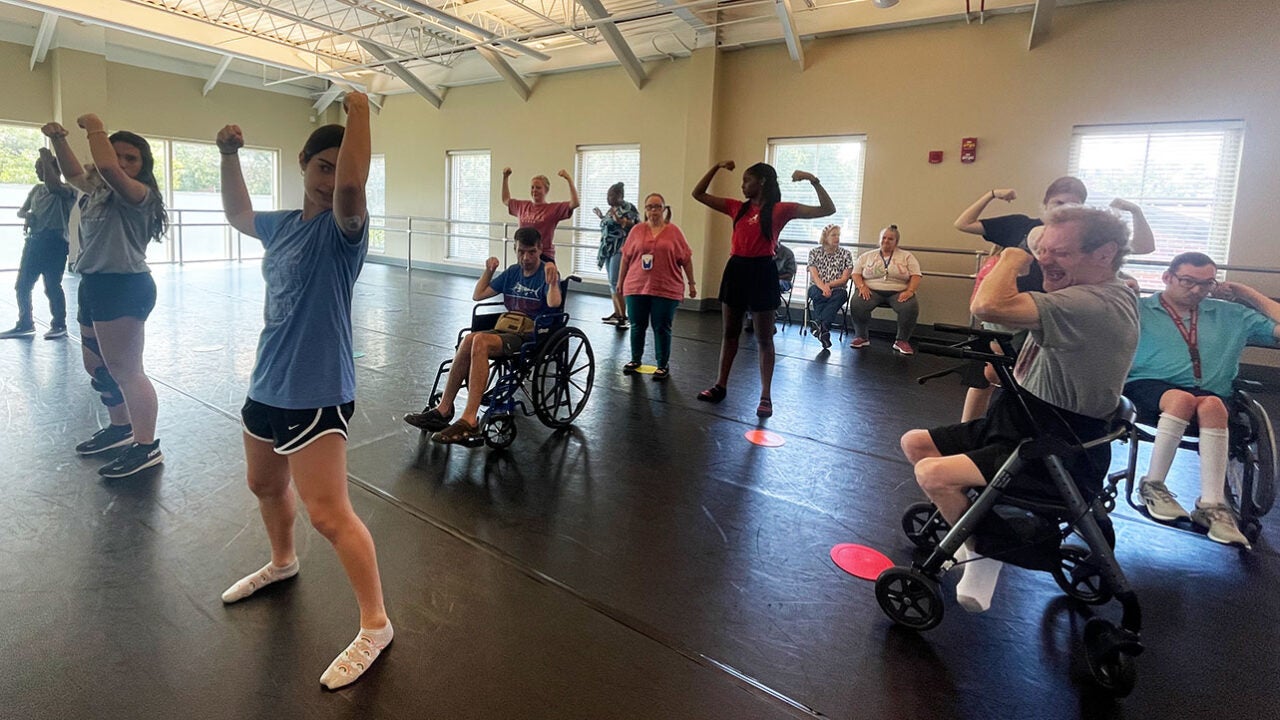 A dance student teaches a routine to adults with Cerebral Palsy.