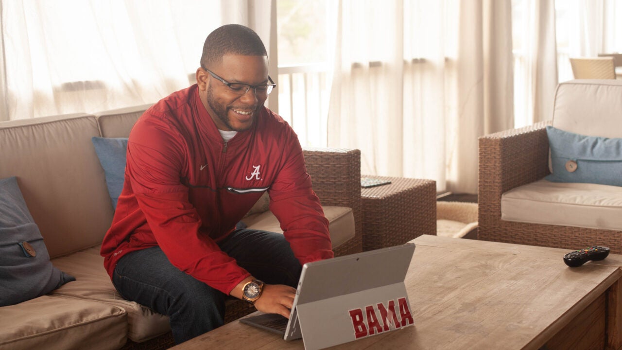 a young man works on a computer at home.