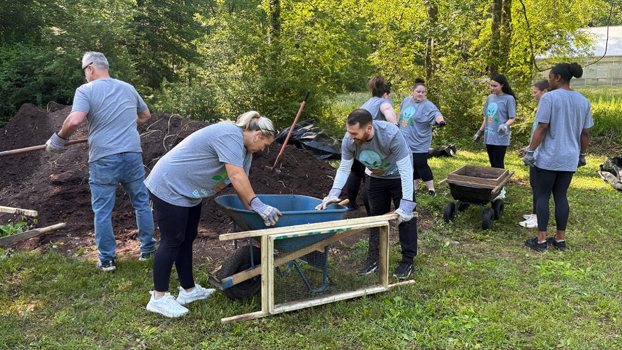 People working with compost at an arboretum.