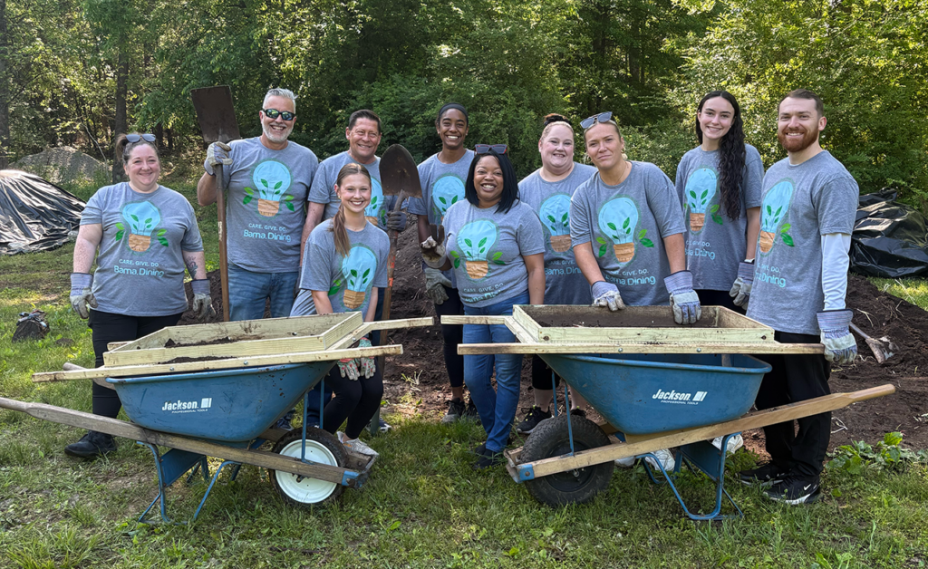 A group of people pose with compost.