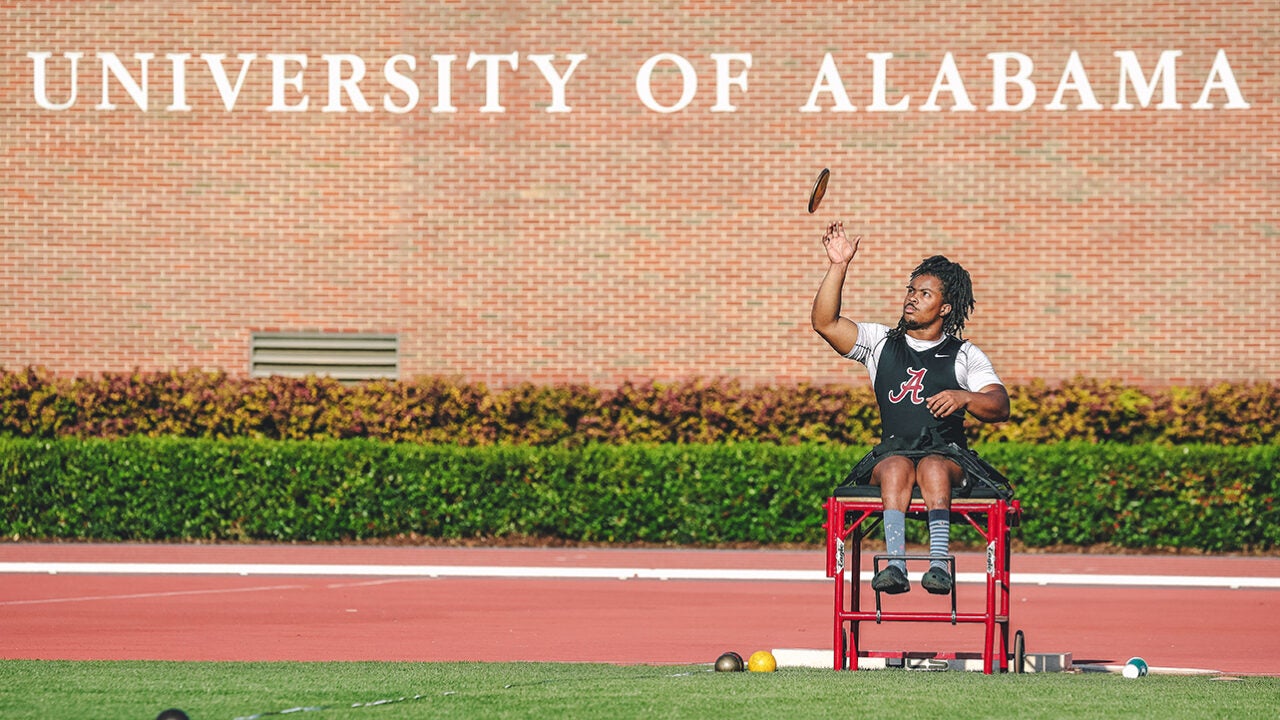 Eric Francis in front of a sign that reads University of Alabama.