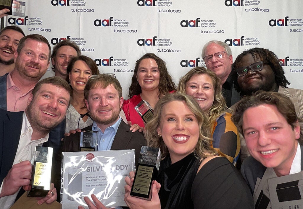 A group of people pose with an ADDY award.