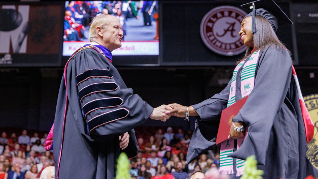 Stuart Bell shaking the hand of a student at graduation