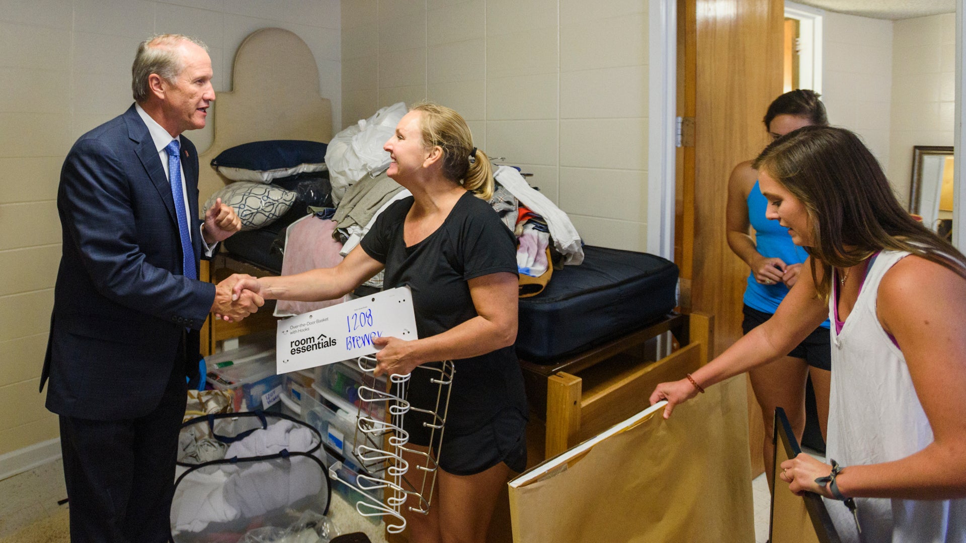 Dr. Bell shakes hands with a mother in her daughter's dorm room during move in day