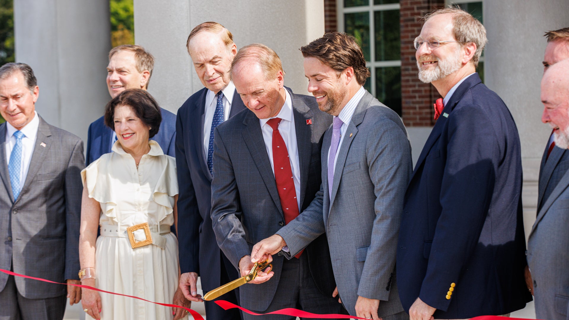 Dr. Bell and other dignitaries cut the ribbon on a new building