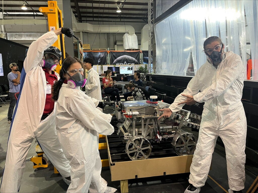 Members of the UA lunar robotics team point to the lunar rover.