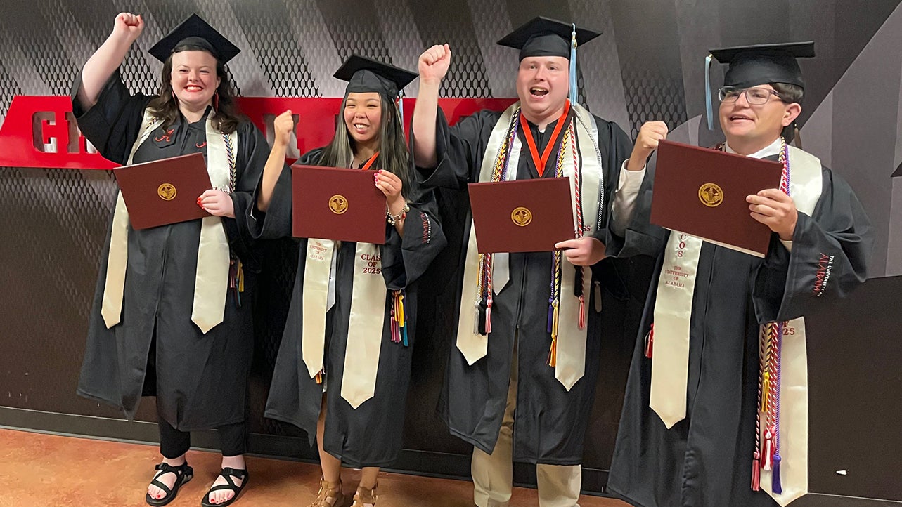 Students in commencement regalia celebrate.
