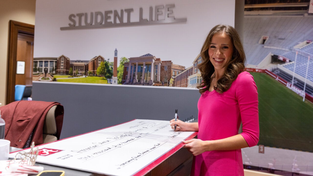Hannah Adams signs a giant check