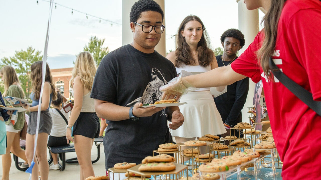 Student getting free cookies from a welcome event