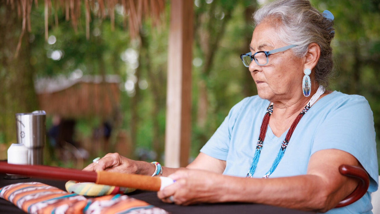 An exhibitor sewing material at a previous festival
