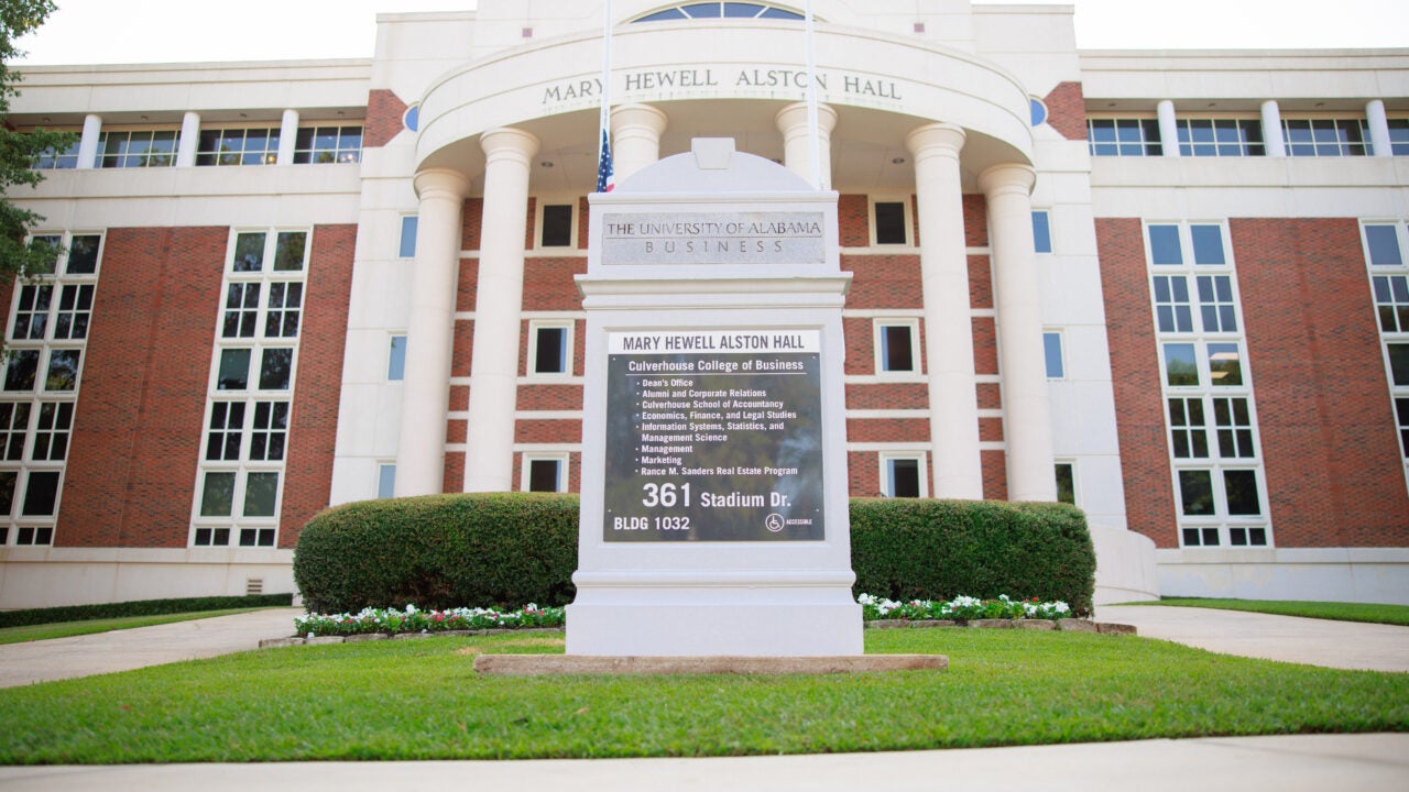 A sign in front of an academic building.