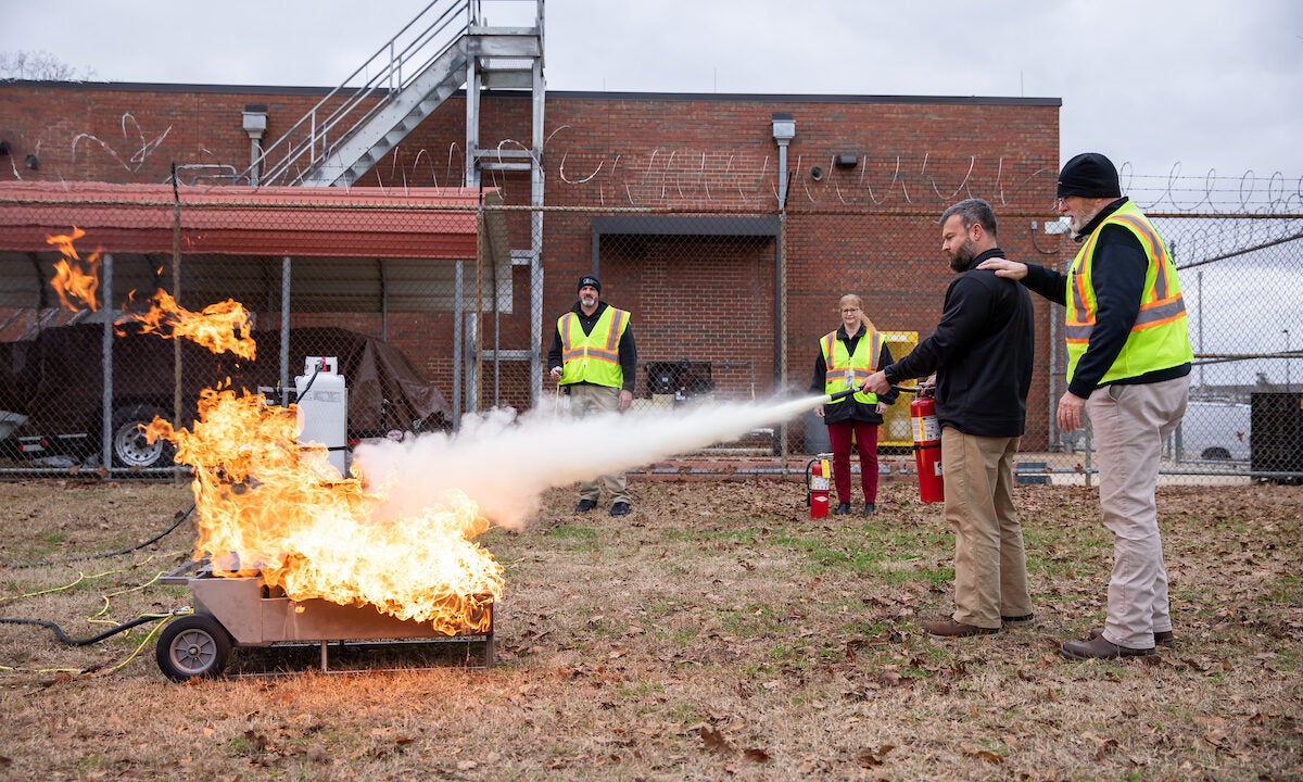 A man uses a fire extinguisher to put out a fire.