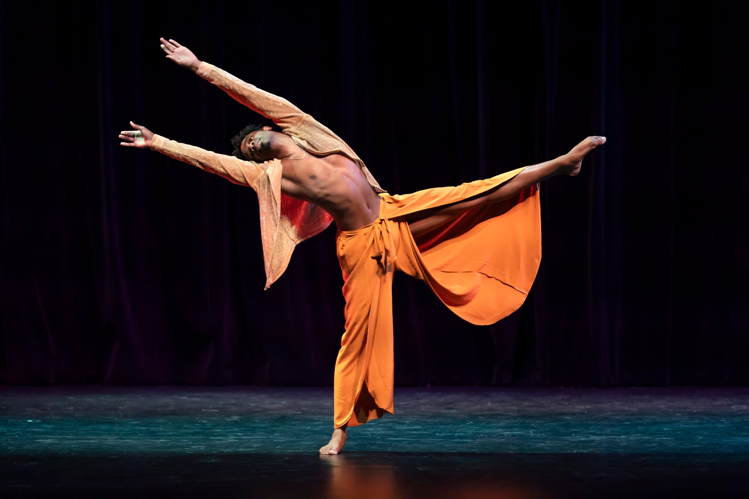 Micah courtland dances with his arms and leg outstretched