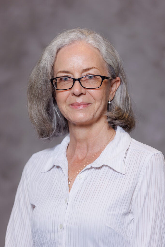 Headshot of Dr. Katia Matcheva in front of a gray background. 
