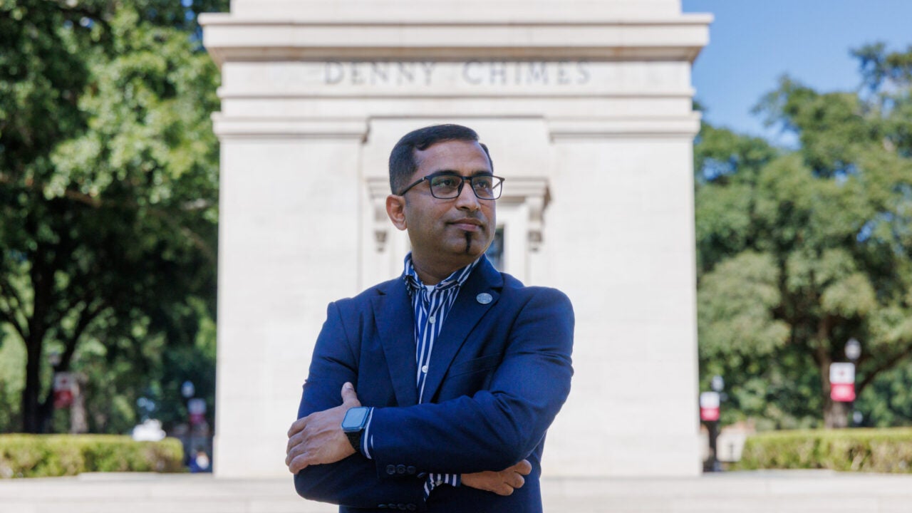 Thejesh Bandi stands in front of Denny Chimes with his arms crossed