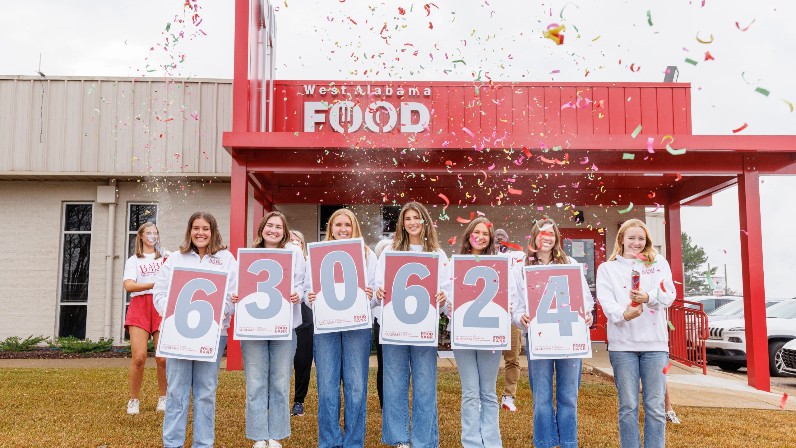 Students involved with Beat Auburn Beat Hunger showing number signage revealing the total donations raised this year