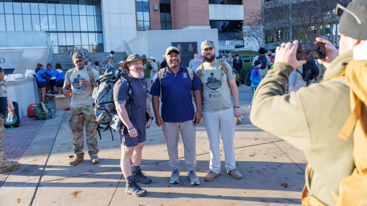 three iron ruck participants smile while having a photo taken