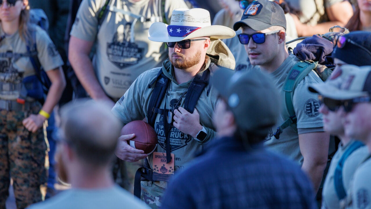 a veteran holds a football at the operation iron ruck kickoff