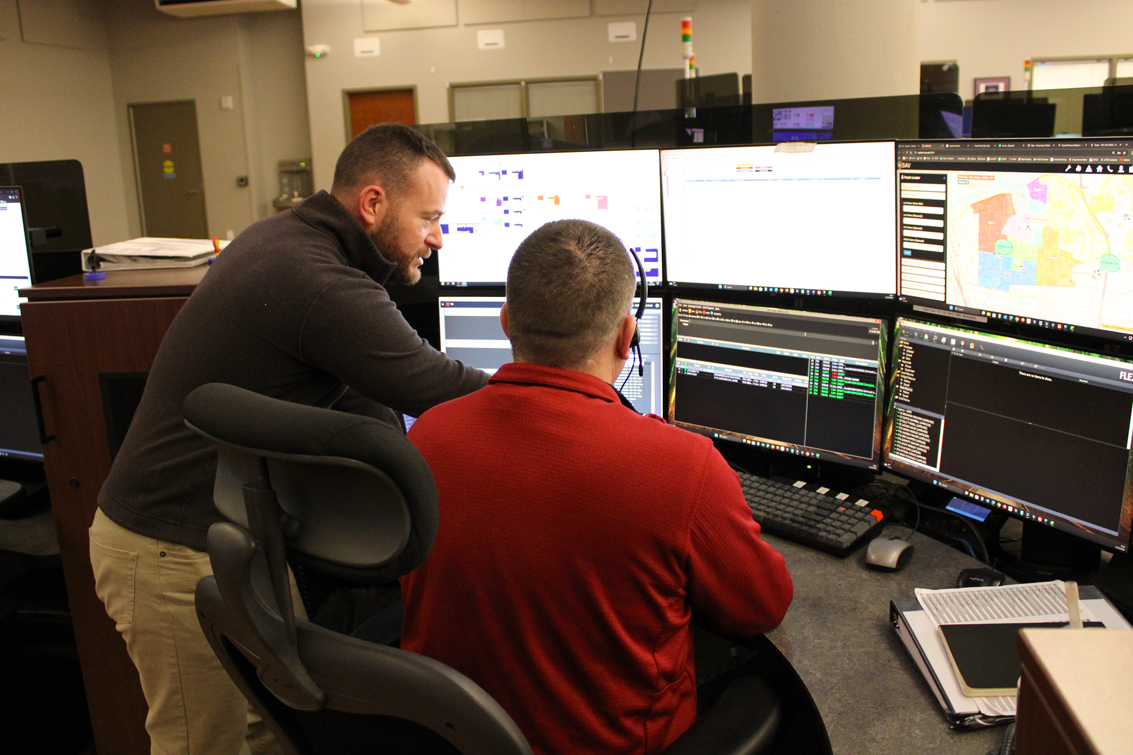 A UAPD Communications trainer discusses a call with a new police telecommunicator.
