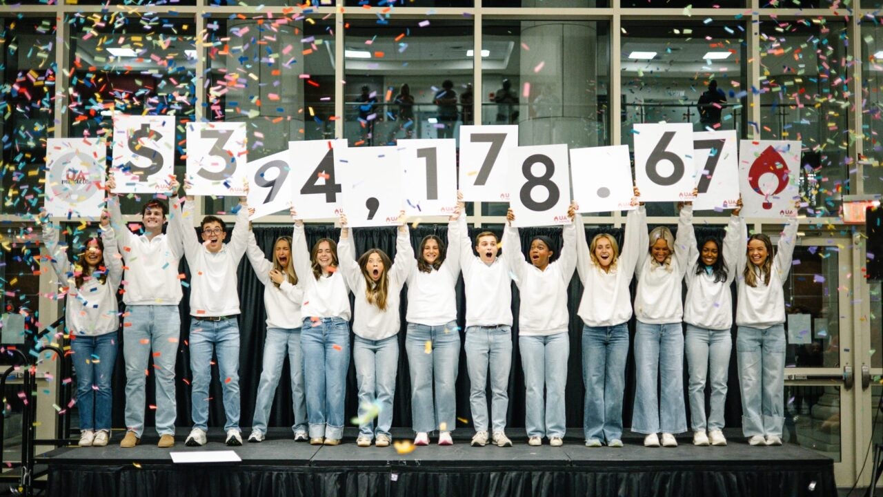 UA Miracle participants holding number cards revealing the total amount raised