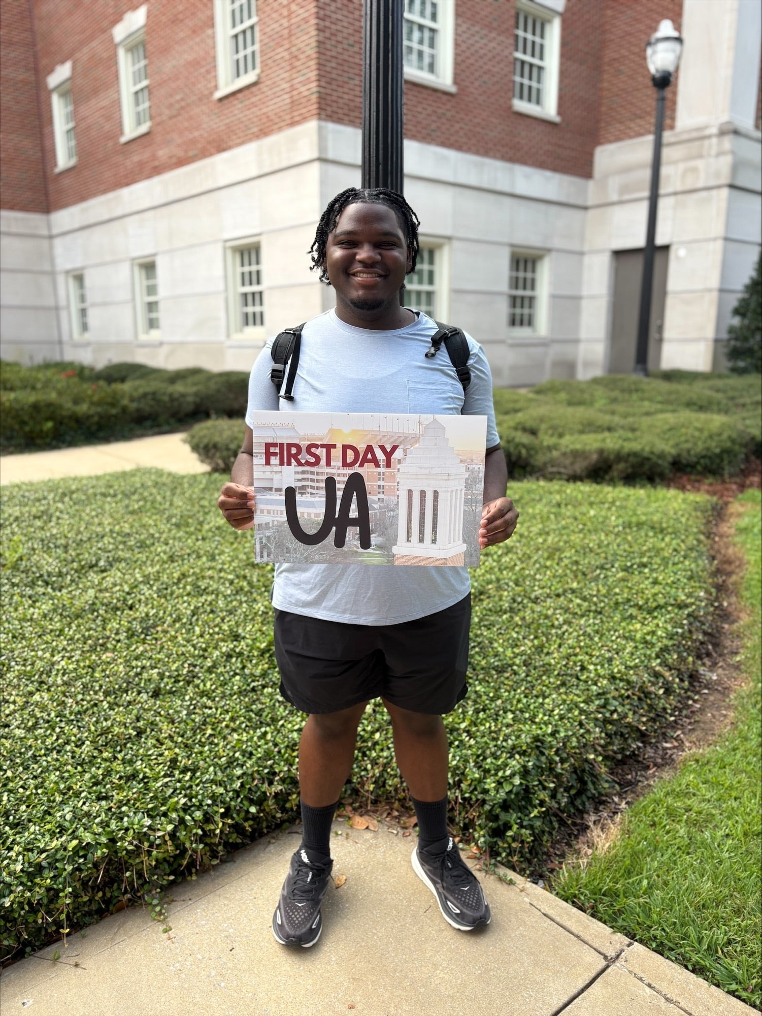 Student holding up "First Day UA" sign on campus
