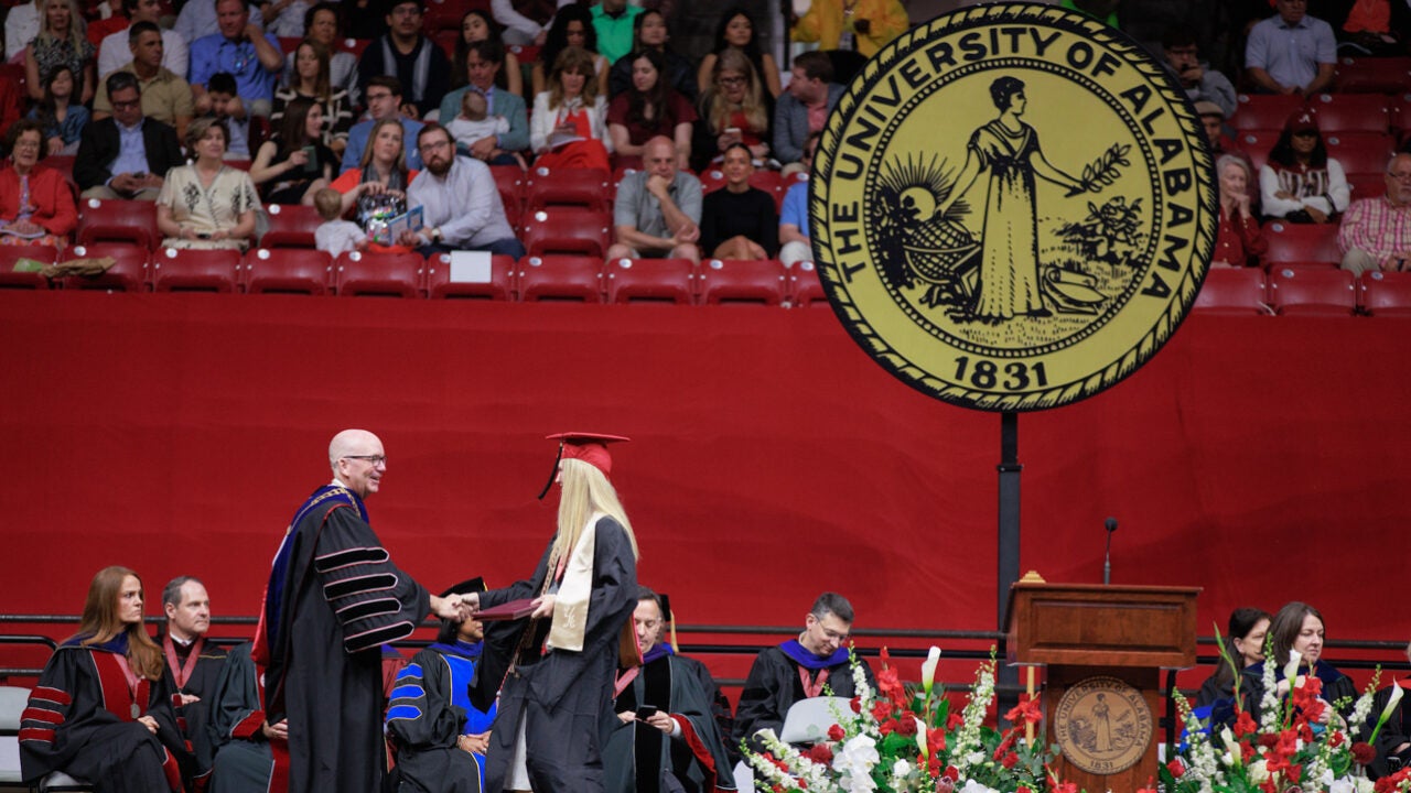 President Mohler shakes a graduate's hand on the stage