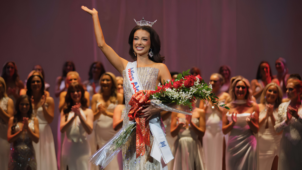 Tilghman smiling and waving while wearing the Miss Alabama crown and holding a flower bouquet.