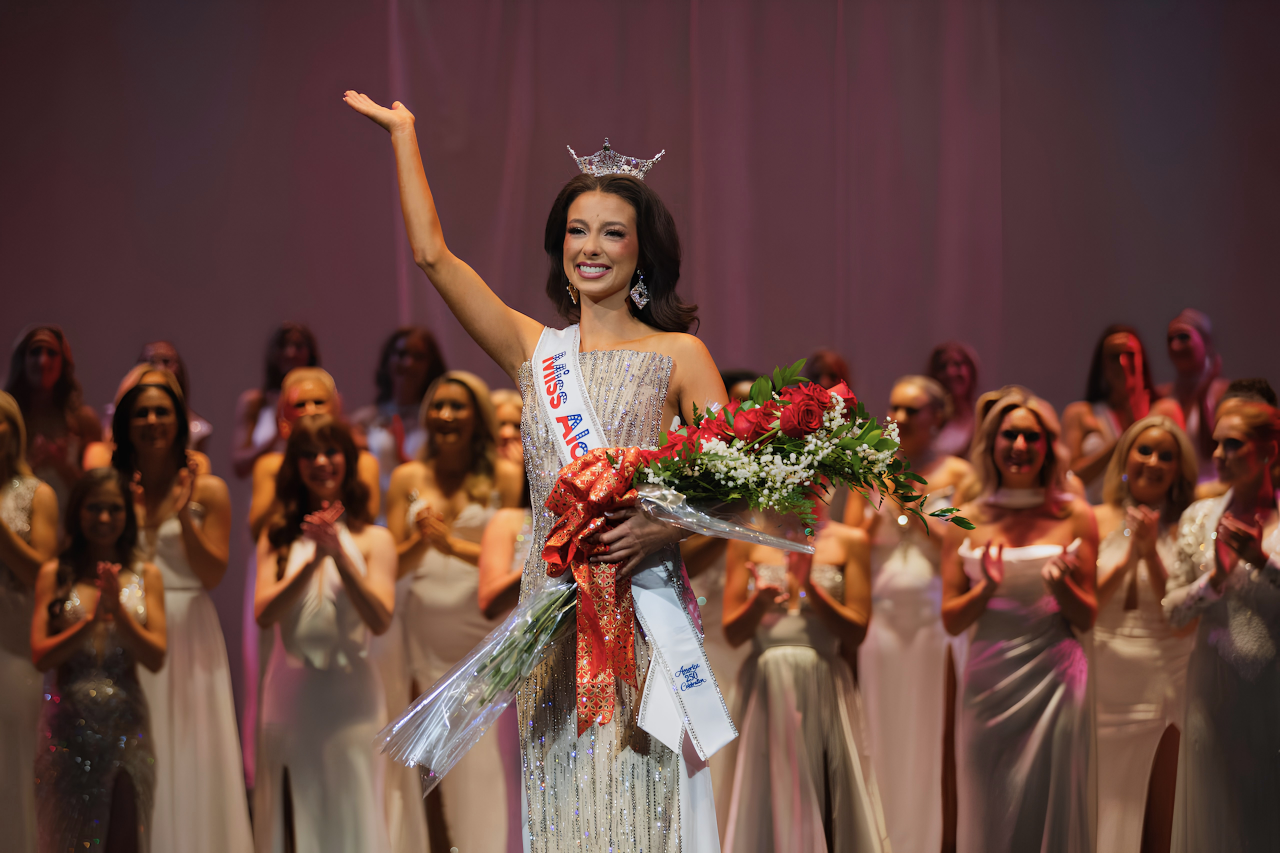 Tilghman smiling and waving while wearing the Miss Alabama crown and holding a flower bouquet.