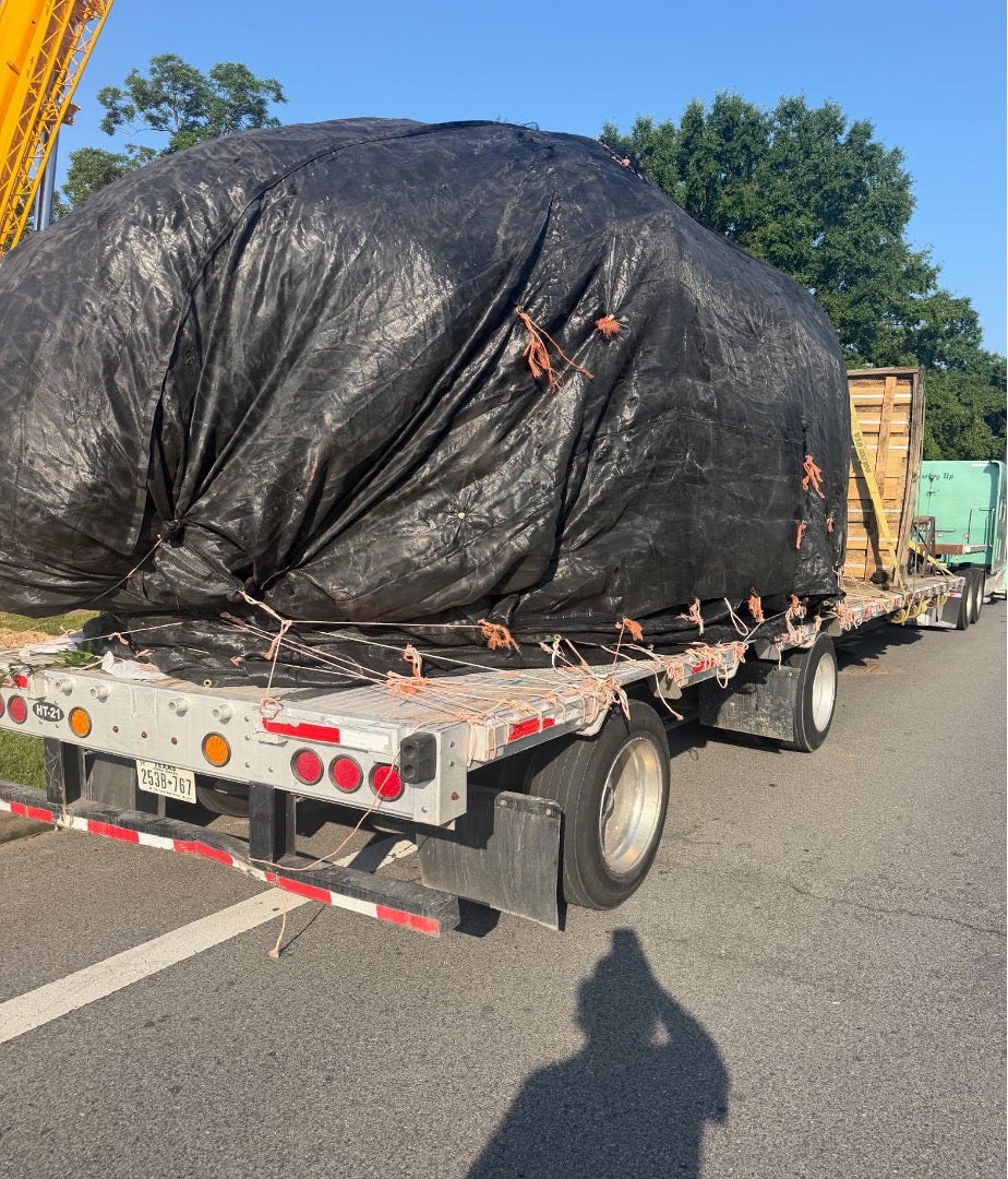 A new oak covered with tarp on a flatbed truck