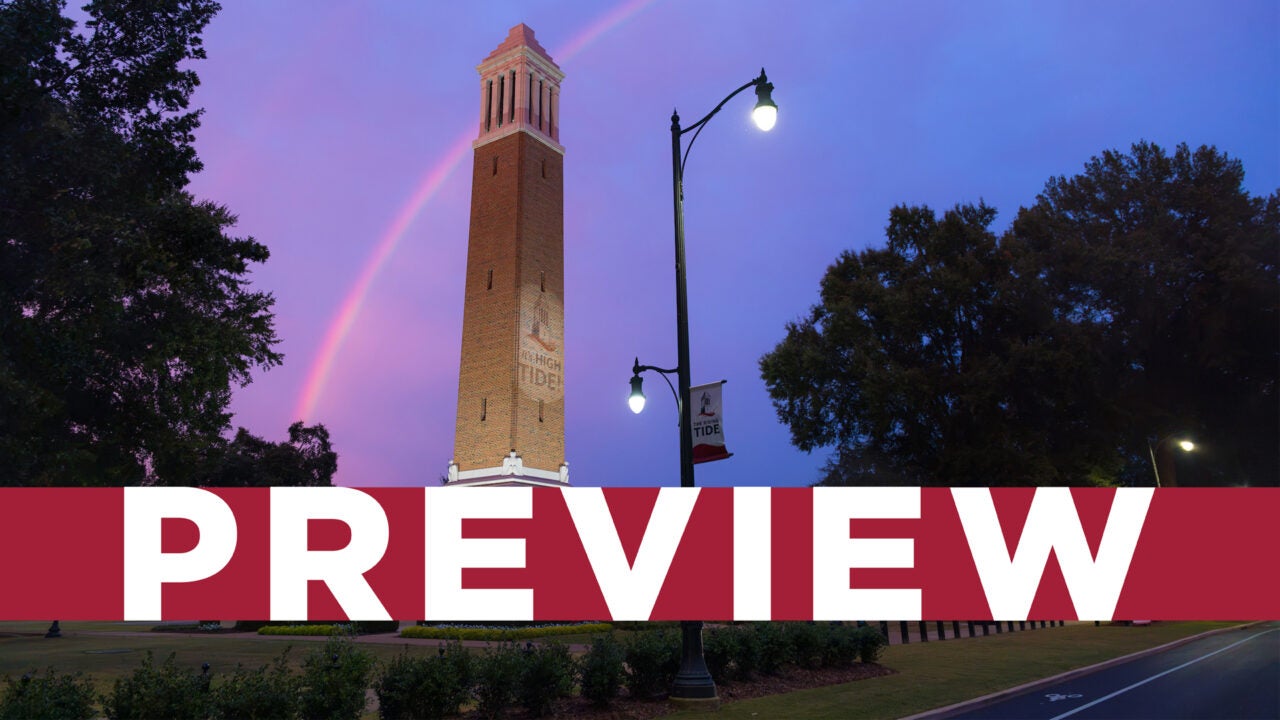 The saying It's High Tide projected on Denny Chimes and a rainbow in the distance